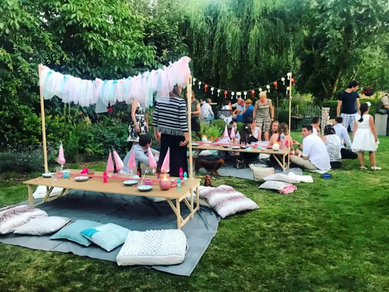 Picknick met kussens en een witte tent in de tuin