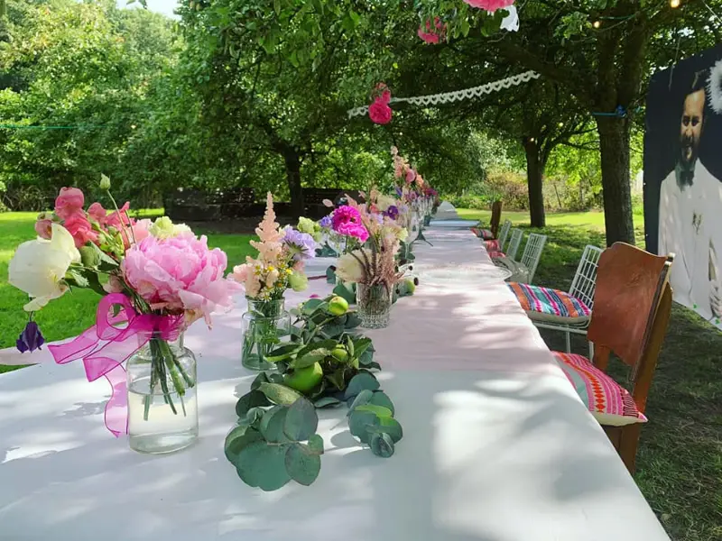 Lange gedekte tafel met bloemen in de tuin
