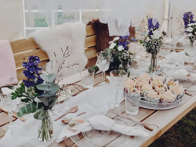 Gedekte tafel met bloemen en hapjes